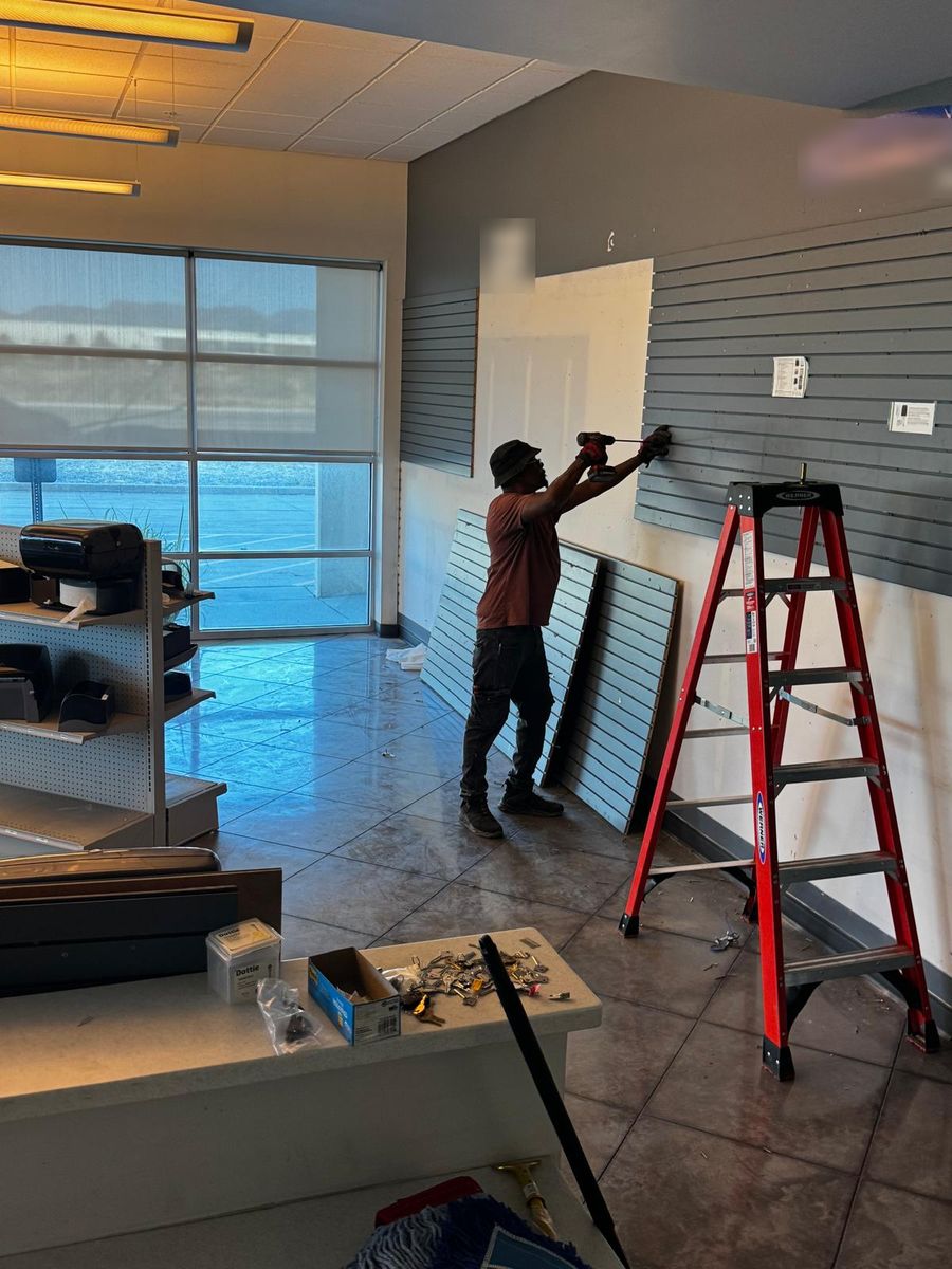 NWCS crew member removing slatwall panels from a retail showroom
