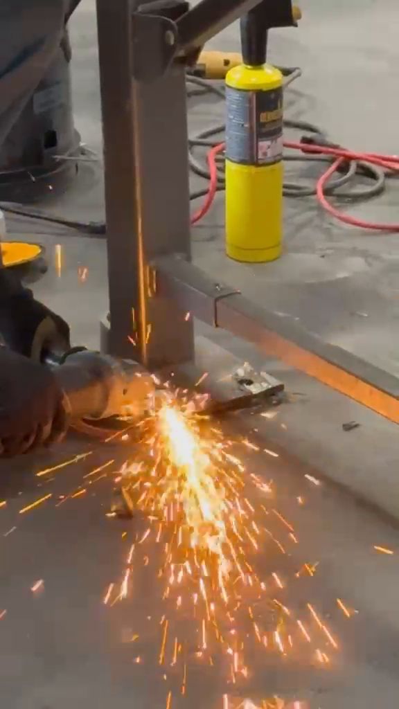 Grinder cutting anchor bolts flush with the warehouse floor